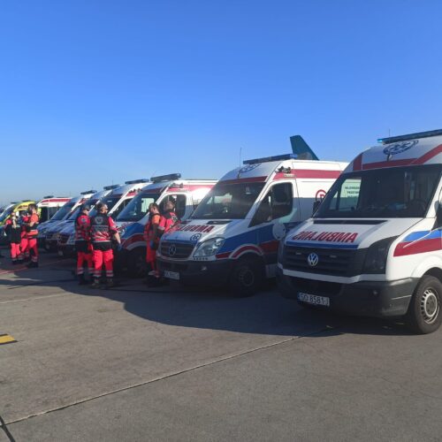 Ambulansy ustawione na tafli lotniska.